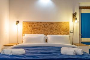 a bedroom with a large bed with two white pillows at Elsa d'Ortigia - I Tre Archi in Syracuse