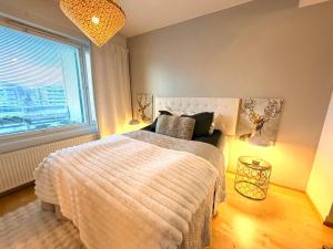 a bedroom with a bed and a large window at Big river view city apartment in Rovaniemi