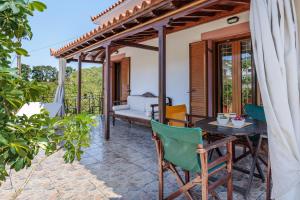 a patio of a house with a table and chairs at Studios Galini in Skopelos Town