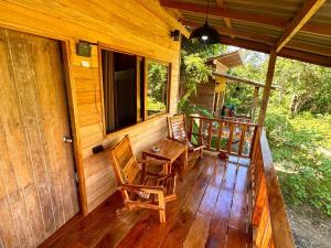 a porch of a cabin with a table and chairs at Koh Mook Banana Garden in Ko Libong