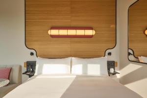 a bedroom with a white bed with a wooden headboard at The Standard, Singapore in Singapore +84 photos