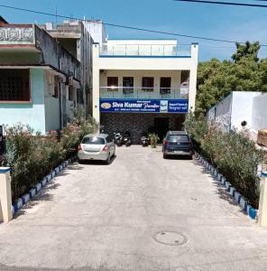 two cars parked on a street in front of a building at Sivakumar paradise in Mahabalipuram