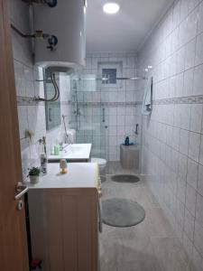 a bathroom with a sink and a shower and a toilet at Studio apartman KONAK in Kupres