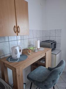 a small kitchen with a wooden table with a chair at Studio apartman KONAK in Kupres