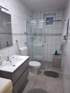 a bathroom with a toilet and a shower and a sink at Studio apartman KONAK in Kupres