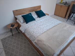 a bedroom with a large bed with blue pillows at Studio apartman KONAK in Kupres