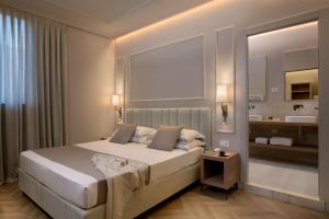 a bedroom with a large bed and a bathroom at Hotel San Gregorio in Pienza
