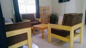 Elle comprend un salon doté d'un mobilier en bois et d'une fenêtre. dans l'établissement Gray Hideaway Resort, à Jinja