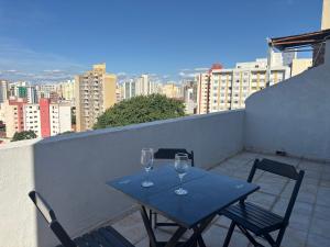a blue table with two wine glasses on a balcony at Apes Raizes Douradas in Campinas