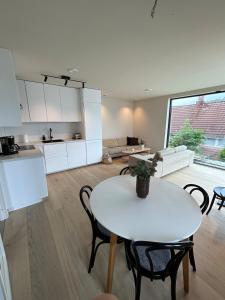 a kitchen and living room with a white table and chairs at Sentral leilighet in Egersund