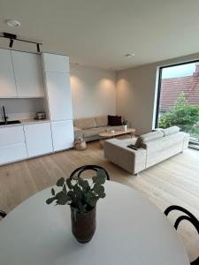 a living room with a table and a couch at Sentral leilighet in Egersund