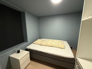 a small bedroom with a bed and a window at Sentral leilighet in Egersund +3 photos