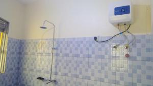 La salle de bains est pourvue d'une douche et de carrelage bleu. dans l'établissement Gray Hideaway Resort, à Jinja