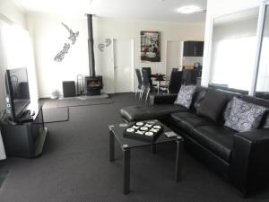 a living room with a black couch and a tv at Hillsborough Hideaway in Hillsborough