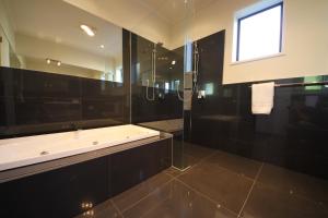 a black bathroom with a tub and a shower at Hillsborough Hideaway in Hillsborough