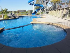 a large pool of blue water with a slide at Hillsborough Hideaway in Hillsborough
