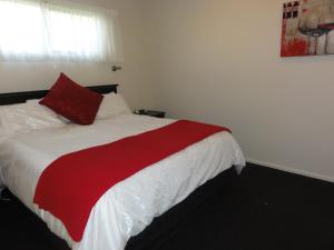 a bedroom with a bed with a red and white blanket at Hillsborough Hideaway in Hillsborough