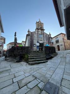 Ein Mann steht vor einem alten Gebäude. in der Unterkunft Ático Pequeño Paraíso Combarro in Combarro