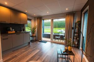 a kitchen with wooden floors and a large window at Tiny Boat House #4 in Garnwerd