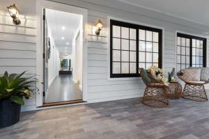 eine Veranda mit einer Tür und einem Tisch und Stühlen in der Unterkunft Homestead on Fennell - Fresh Eggs, Farm & BBQ Fun in Toronto