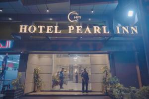 two police officers standing in front of a hotel pearl inn at Hotel pearlinn karachi in Karachi