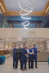 a group of men in uniform standing in a lobby at Hotel pearlinn karachi in Karachi