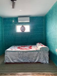 ein blaues Zimmer mit einem Bett und einem Fenster in der Unterkunft Rhino Spot Resort in Meghauli + 8 Fotos