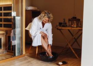 a woman in a towel sitting in a bowl at GiteLaGrange in Lalanne-Arqué