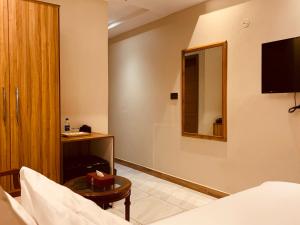 a hotel room with a bed and a table and a mirror at Hotel pearlinn karachi in Karachi