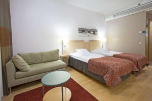 a hotel room with a bed and a couch at Scandic Oulu City in Oulu +36 photos