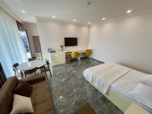 ein Schlafzimmer mit einem Bett und einem Schreibtisch mit einem Fernseher in der Unterkunft LARTA Rest House in Ashtarak