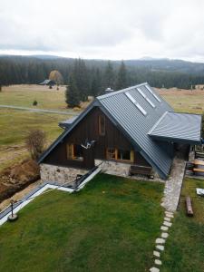 una casa con tetto di metallo su un campo di Apartmány Modrava a Modrava