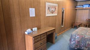 een kamer met een bed, een dressoir en een bureau bij Black Cat Guest Ranch in Brule Mines