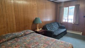 een slaapkamer met een bed, een stoel en een raam bij Black Cat Guest Ranch in Brule Mines