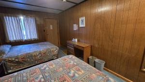 een hotelkamer met twee bedden en een bureau bij Black Cat Guest Ranch in Brule Mines +12 foto's