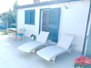 two white chairs and a table on a patio at La casa tra le vie in Viagrande