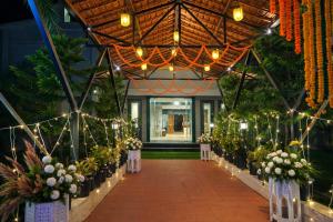 een gang met bloemen en lichtjes in een gebouw bij Corbett Selva Resort By DevStayZ in Rāmnagar