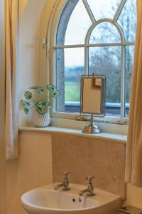een badkamer met een wastafel en een raam bij Bath Lodge in Tormarton