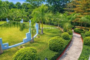Een luchtfoto van een park met palmbomen en een pad. bij Corbett Selva Resort By DevStayZ in Rāmnagar