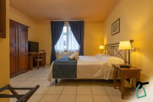a bedroom with a bed and a window at Hotiday Toscana Riparbella in Riparbella
