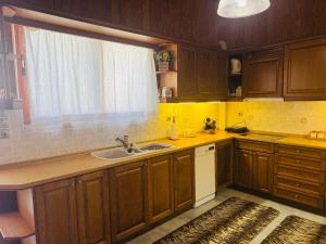 a kitchen with wooden cabinets and a sink and a window at Mani Beach House in Vathia +17 photos