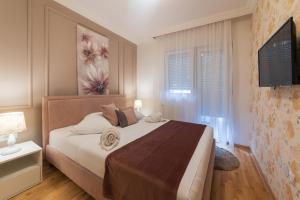 une chambre avec un grand lit et une télévision dans l'établissement NAR Royalton Accommodation, à Niš