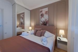 une chambre avec un grand lit avec des serviettes dessus dans l'établissement NAR Royalton Accommodation, à Niš