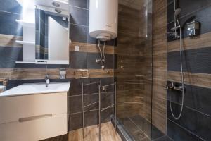 une salle de bain avec lavabo et douche dans l'établissement NAR Royalton Accommodation, à Niš