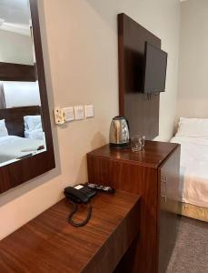 a hotel room with a telephone and a bed at فندق منارة العزيزية in Al Gharīth