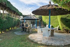 un patio con tavolo, ombrellone e sedie di Alojamientos Nacarum a El Palmar