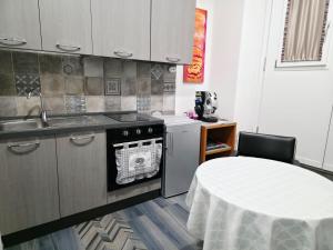 a kitchen with a table and a sink and a stove at Casa Vacanze 21 Ventuno in Antrodoco