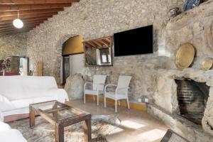 un soggiorno con un muro in pietra e un camino di Alojamientos Nacarum a El Palmar
