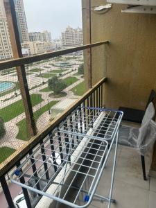 a bed on a balcony with a view of a park at OST Homes Rolla Park in Sharjah