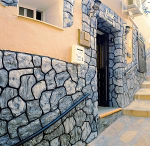 un edificio con un muro di pietra e una porta di Apartamento La Vista ad Algarrobo